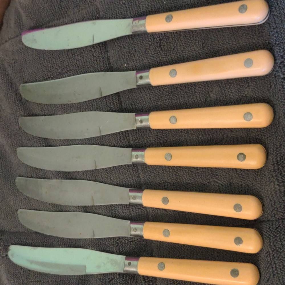 Set of 7 vintage Mardi Gras stainless table knives peach handles